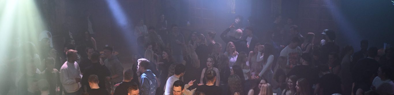 Altes Sägewerk Großzügiger Veranstaltungsraum mit bunten Lichtern und dekorativem Bodenmuster.